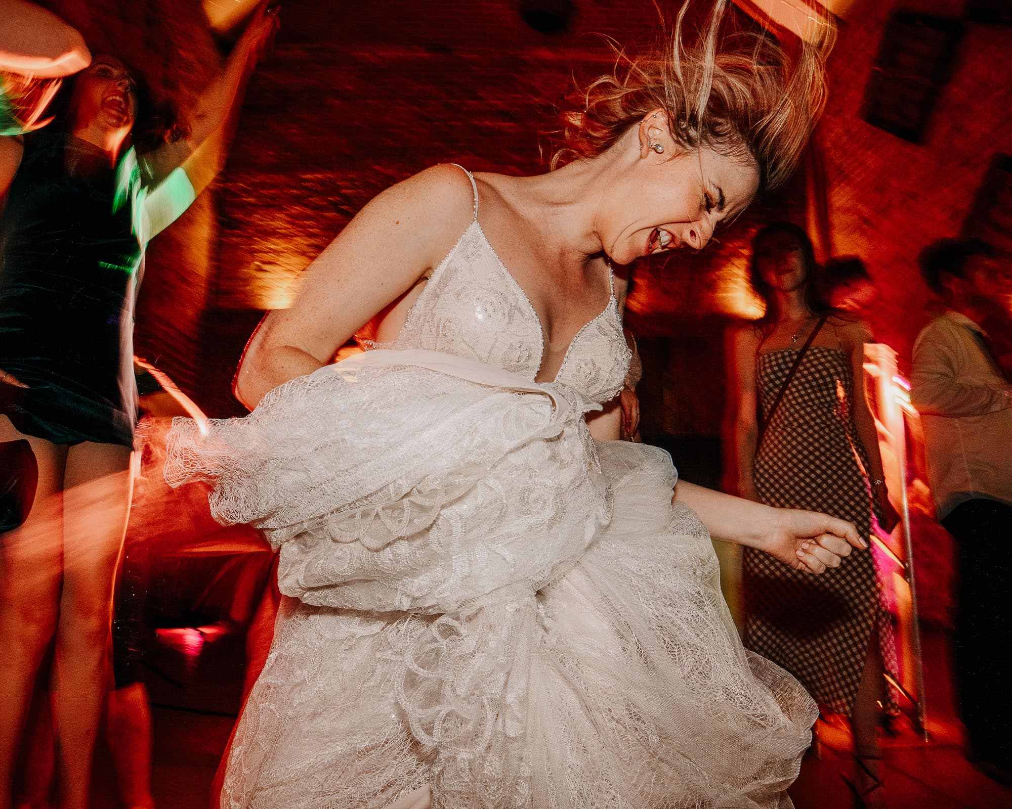 Bride letting her hair down and playing air guitar in her wedding dress